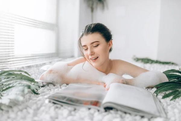 Kobieta Leżąc Kąpieli Pianką Czytanie Książki Relaks Zdrowie Pielęgnacja Skóry — Zdjęcie stockowe