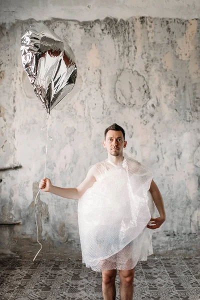 Freak Nagi Człowiek Owinięte Folie Pakowania Trzymając Balon Błyszczący Wnętrza — Zdjęcie stockowe