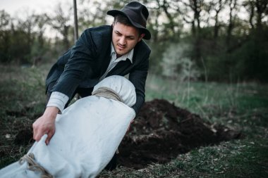 Manyak bir mezar, seri katil kavramı, suç korku karşı bir tuval sarılı ve kurbanın ile