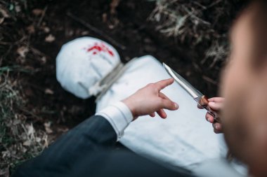Mezar, sarılmış bir tuval, seri katil kavramı, suç korku, şiddet kurbanı karşı bıçakla kanlı avcı