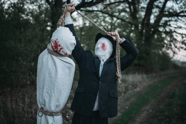 Seri manyak bir tuval üzerine bir ağaç, çılgın katil kavramı, psikopat katil sarılı kurbanın sallanmaktadır