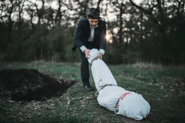 Avcı kurbanın cesedinin sarılı bir tuval içine bir mezar, seri manyak kavramı, gece suç, şiddet sürüyor