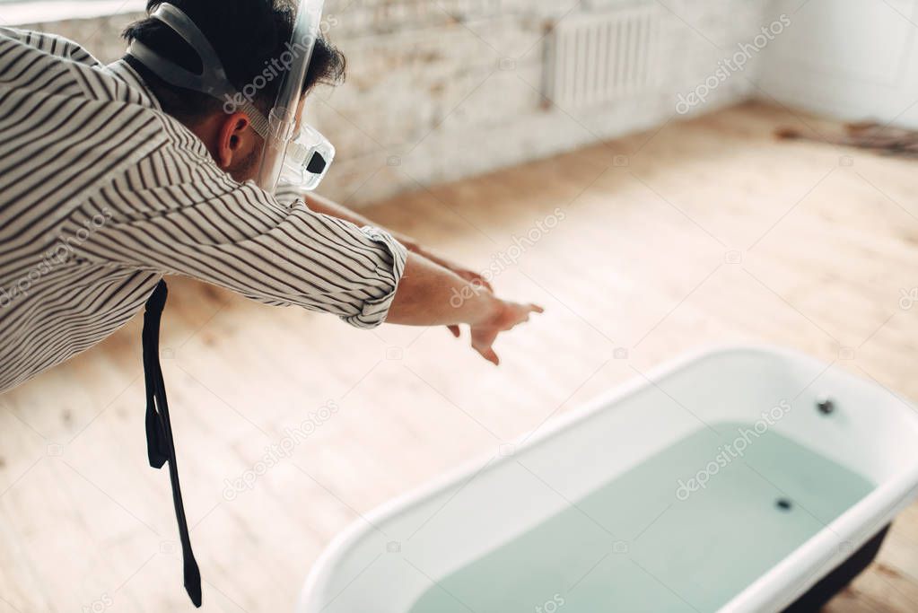 Funny businessman in mask dives into the bathtub, humor. Business fortune concept