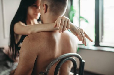 Bir sandalye, erotik iç çamaşırı seksi çift sarılmak. Erotik sahne, erkek ve kadın cinsel ilişki