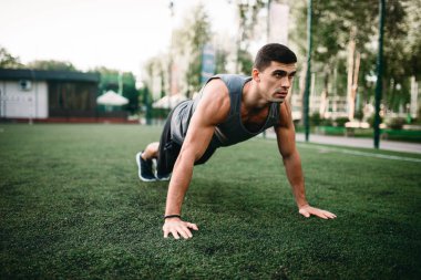 Dolgulu bir ot, açık alan fitness egzersiz egzersiz yapan atletik erkek. Kaslı sporcu spor eğitim yaz Park