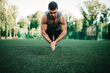 Dolgulu bir ot, açık alan fitness egzersiz egzersiz yapan atletik erkek. Kaslı sporcu spor eğitim yaz Park