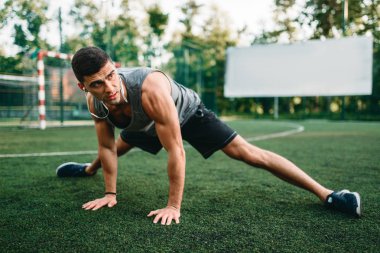 Erkek atlet açık fitness egzersiz üzerinde. Sporcu çim ve germe egzersiz yapıyor üzerinde oturur