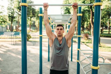 Erkek atlet açık fitness egzersiz egzersiz yatay çubuk üzerinde yapmak. Güçlü sporcu spor eğitim Parkı