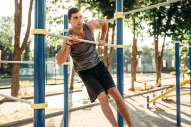 Açık fitness egzersiz egzersiz yatay çubuğu'nda yapan atletik erkek. Spor eğitim güçlü sporcu