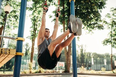 Açık alan fitness egzersiz bar, yatay kullanarak egzersiz yapan atletik erkek. Güçlü sporcu spor eğitim Parkı