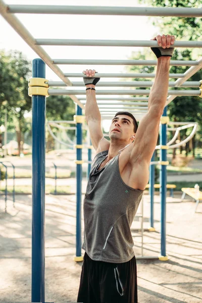 男运动员在水平酒吧训练 户外健身锻炼 强的运动员在夏天公园 — 图库照片