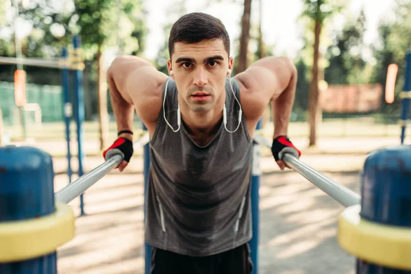 Férfi Atléta Fülhallgató Gyakorlatok Párhuzamos Bárok Szabadtéri Fitness Edzés Erős — Stock Fotó