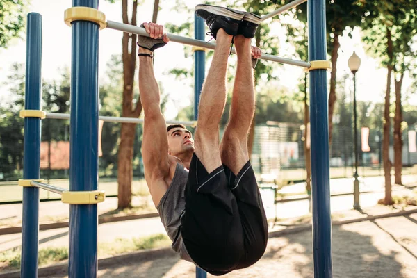 水平バー 屋外フィットネス トレーニングを使用してストレッチ運動を行う運動の男 公園内のスポーツ トレーニングの強いスポーツマン — ストック写真