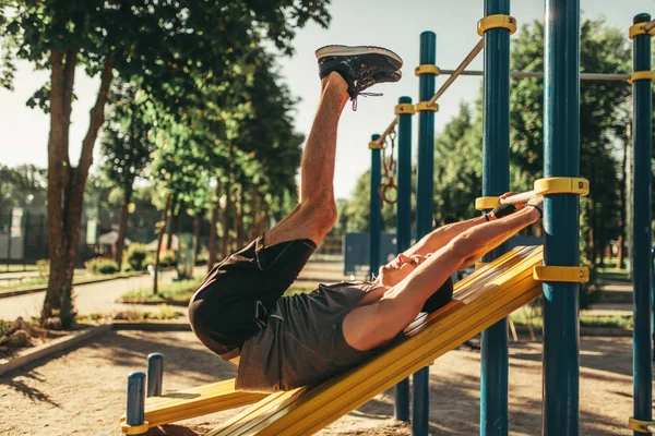 水平バー 屋外フィットネス トレーニングを使って腹筋運動を行うスポーツ ウエアで男 公園内のスポーツ トレーニングの強いスポーツマン — ストック写真