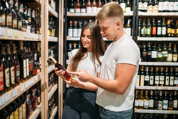 Pareja Joven Buscando Vino Mercado Alcohol Estantes Con Botellas Sobre — Foto de Stock