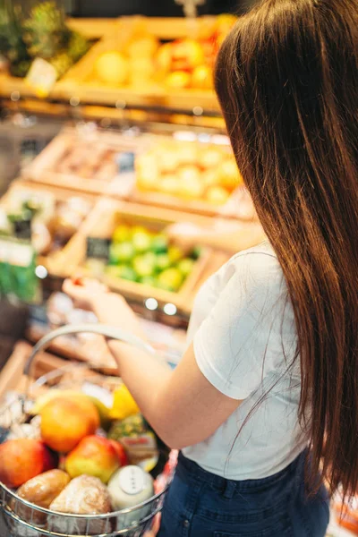 女性顾客与篮子反对果子部分在食物商店 超级市场的妇女购物 — 图库照片