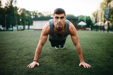 Dolgulu bir ot, açık alan fitness egzersiz egzersiz yapan atletik erkek