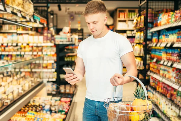 Männliche Kundin Mit Obstkorb Nutzt Handy Supermarkt Mann Lebensmittelladen Oder — Stockfoto