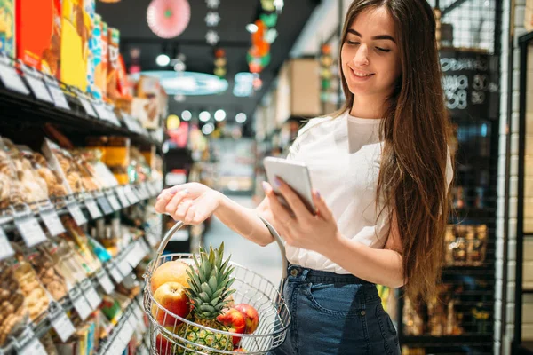 Cliente Femenino Con Cesta Frutas Utiliza Teléfono Móvil Supermercado Mujer —  Fotos de Stock