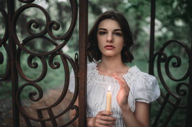Kadın kurban ormandaki yaşlı mezarlığın kapılarında. Fotoğraf korku tarzı, şeytan çıkarma
