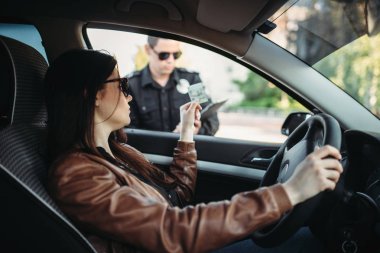 Erkek polis üniforması giyen güzel bir kadın sürücüye yazar. Hukuk koruma, araba trafik müfettişi, Emanet denetim iş
