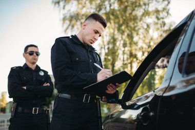Üniformalı erkek polis memurları araç yolda kontrol edin. Hukuk koruma, araba trafik müfettişi, Emanet denetim iş