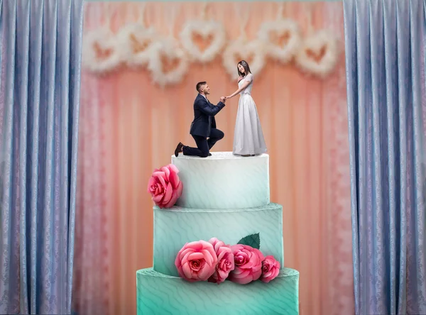 Wedding cake with bride and groom statuettes on the top. Bridal pie for newlyweds with little figurines, traditional celebration ceremony symbol