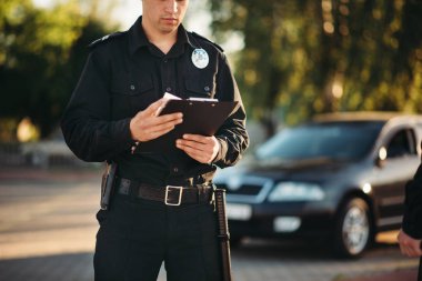 Üniformalı polis elinde defter ile yolda araba kontrol edin. Hukuk koruma, araba trafik müfettişi, Emanet denetim iş