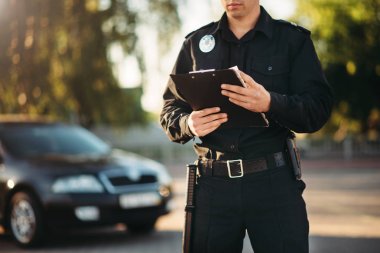 Üniformalı polis elinde defter ile yolda araba kontrol edin. Hukuk koruma, araba trafik müfettişi, Emanet denetim iş