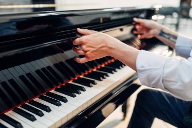 Erkek piyanist siyah kuyruklu piyano klavye kapağını açar. Müzisyen royale, klasik müzik aleti performansına hazırlar
