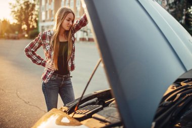 Araba arıza kavramı, yol kenarında kaputa karşı duran kadın açın. Kadın sürücü motor kırık araç görünüyor