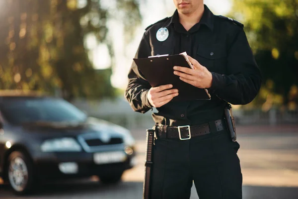 警察穿着制服 手里拿着笔记本检查路上的汽车 法律保护 汽车交通检查员 安全控制工作 — 图库照片