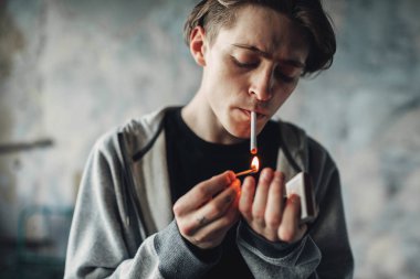 Genç adam Sigara İçilmeyen, grunge arka plan. Bağımlılık kavramı, sigara uyuşturucu