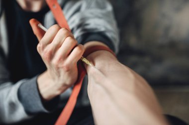 Erkek keş bir enjeksiyon dozu kolundan yapıyor bir şırınga. Alkolizim kavramı, insanlar uyuşturucu bağımlısı