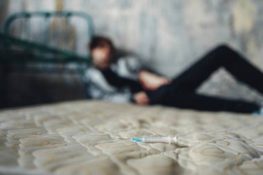 Yatakta, doz sonra arka plan üzerinde uyku keş şırınga. Uyuşturucu bağımlılığı kavramı, insanlar uyuşturucu bağımlısı