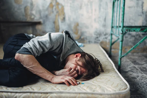 男性吸毒者用注射器在手睡在床后剂量 上瘾概念 麻醉上瘾的人 — 图库照片
