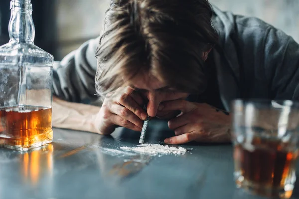 Hombre Drogadicto Oliendo Una Línea Cocaína Drogas Botella Alcohol Mesa —  Fotos de Stock