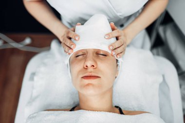 Şevval özçelik güzellik el losyonları kadın hasta yüzü, üstten görünüm, klinik kozmetik krem. Yüz cilt bakımı, spa salonu yordamda gençleştirme