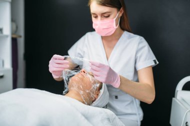 Doktor, yüz maskesi, kırışıklık, kozmetik klinik kurtulmak yapıyor. Yüz cilt bakımı, gençleştirme yordamı spa salonda, sağlık