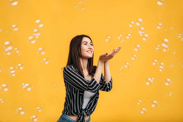 Hübsche Frau Fängt Seifenblasen Gelber Hintergrund — Stockfoto