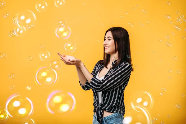 Pretty Woman Catching Soap Bubbles Yellow Background — Stock Photo, Image