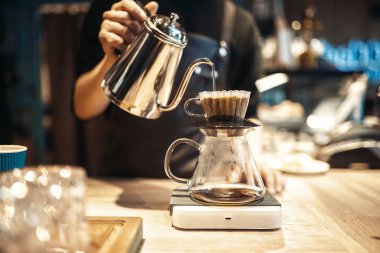 Erkek barista kahve, Cafe counter arka plan üzerinde cam içine kaynar su dökülen. Barmen barmen işgal kafeteryasında tarafından profesyonel espresso hazırlık