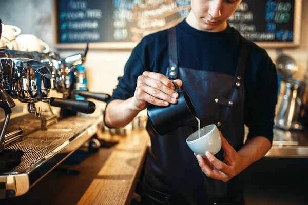 咖啡壶在围裙上倒入奶油杯 背景咖啡馆柜台 专业的卡布奇诺准备由酒保 — 图库照片