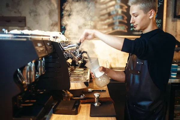 ブラック エプロンの若い男性のバリスタは カプチーノ コーヒー マシンを準備します プロのバーテンダーの職業 — ストック写真