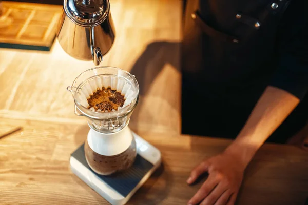 男咖啡师把热水倒入玻璃杯 拿铁准备 在背景上的木制咖啡馆柜台 酒吧招待在自助餐厅工作 酒保做咖啡 — 图库照片