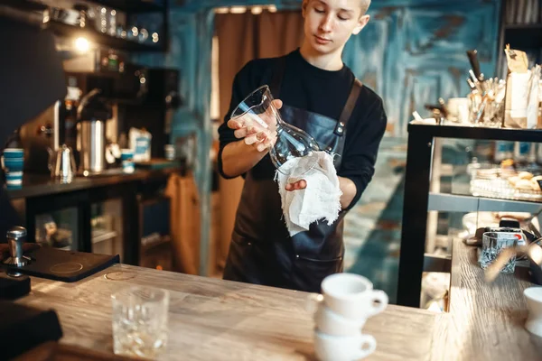 若い男性のバリスタは カフェ カウンターでコーヒーを作る後皿をワイプします バーマンは カフェテリア バーテンダーの職業 — ストック写真