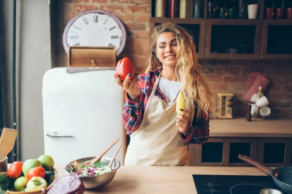 Улыбающаяся Домохозяйка Фартуке Держа Руках Свежий Перец Кухонный Интерьер Заднем — стоковое фото