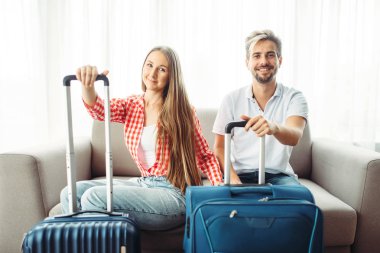Kanepede oturan bavul ile genç çift. Yolculuk kavramı ücretleri. Bagaj hazırlık. Veya turizm seyahat