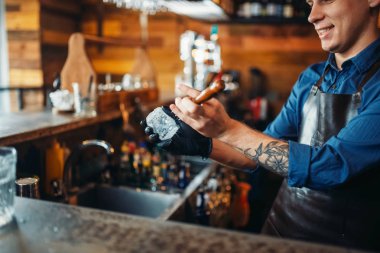 Erkek barmen saplar buz barda sayaç. Alkol içecek hazırlama. Barmen işgal