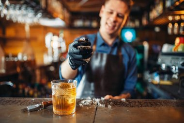 Önlük erkek barmen çalışıyor buz ile barda sayaç. Alkol içecek hazırlama. Barmen işgal